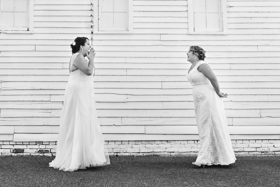 A happy and loving reaction of two brides seeing each other for the first time before their wedding ceremony.